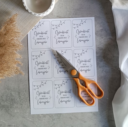 DIY-Geburtstagskarte mit Wunderkerze und der Aufschrift „Glückslicht für ein strahlendes neues Lebensjahr“, dekoriert mit Kerze, Pampasgras und Leinenstoff auf hellem Untergrund.

