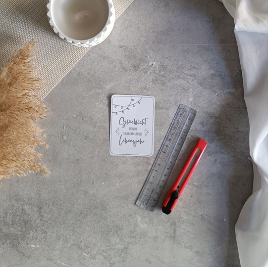 DIY-Geburtstagskarte mit Wunderkerze und der Aufschrift „Glückslicht für ein strahlendes neues Lebensjahr“, dekoriert mit Kerze, Pampasgras und Leinenstoff auf hellem Untergrund.