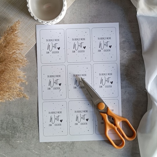 DIY-Karte mit Wunderkerze und der Aufschrift „Du bringst meine Welt zum Leuchten“, liebevoll dekoriert mit Kerze, Pampasgras und hellem Stoff auf Betonoptik-Hintergrund.